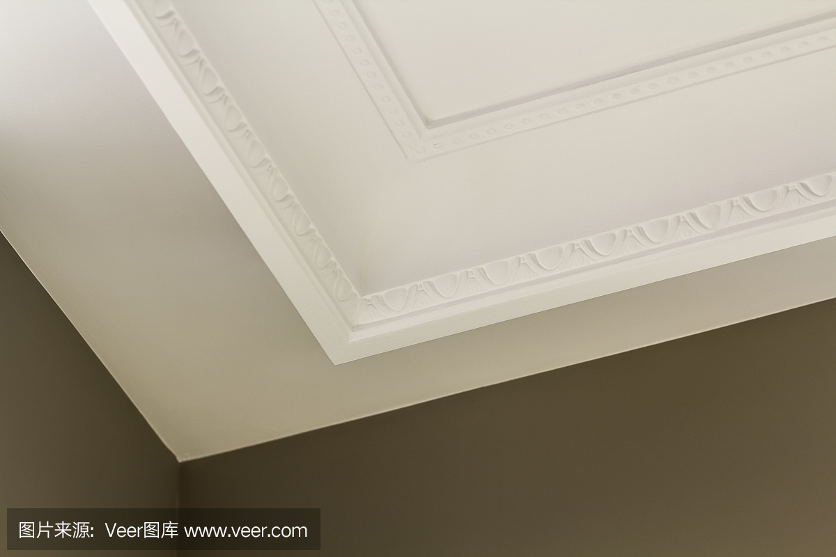 白色房间天花板上装饰性的白色造型装饰特写细节。室内装修和施工概念。